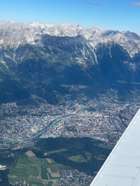 Innsbruck and the river Inn before a high mountain range, aerial view from a Piper
